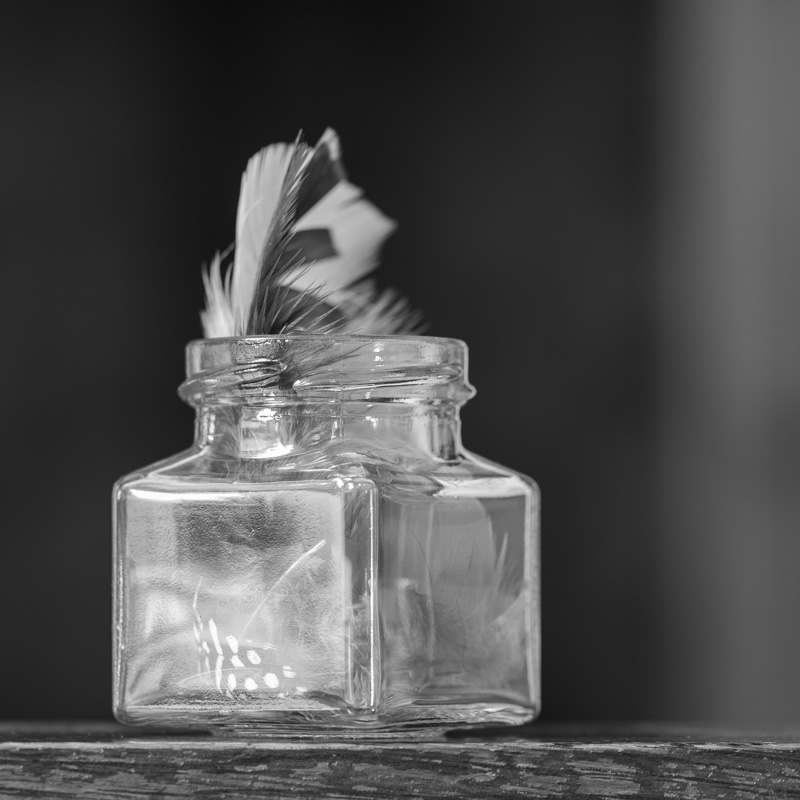Glass bottle with feathers
